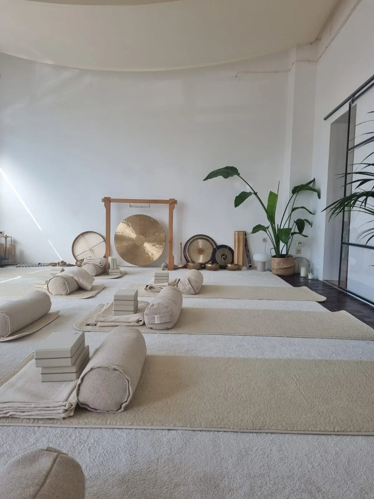 Vorbereiteter Raum für eine Yin-Yoga-Klasse mit Yogamatten und einem großen Gong.