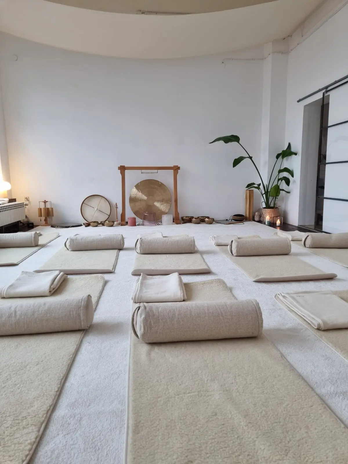 Vorbereiteter Raum für eine Yin-Yoga-Klasse mit Yogamatten und einem großen Gong.